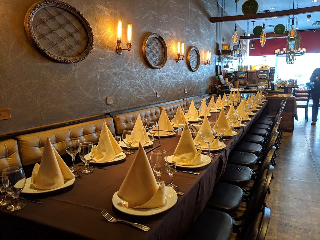 Wow Bistro's dining room set for a party with folded napkins along a long table